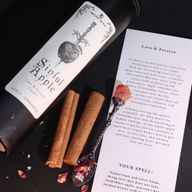 Primer plano de la etiqueta de la vela Sinful Apple, con daga ritual y diseño de manzana