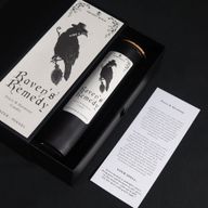 Carta de conjuro ritual Raven's Remedy junto a la vela