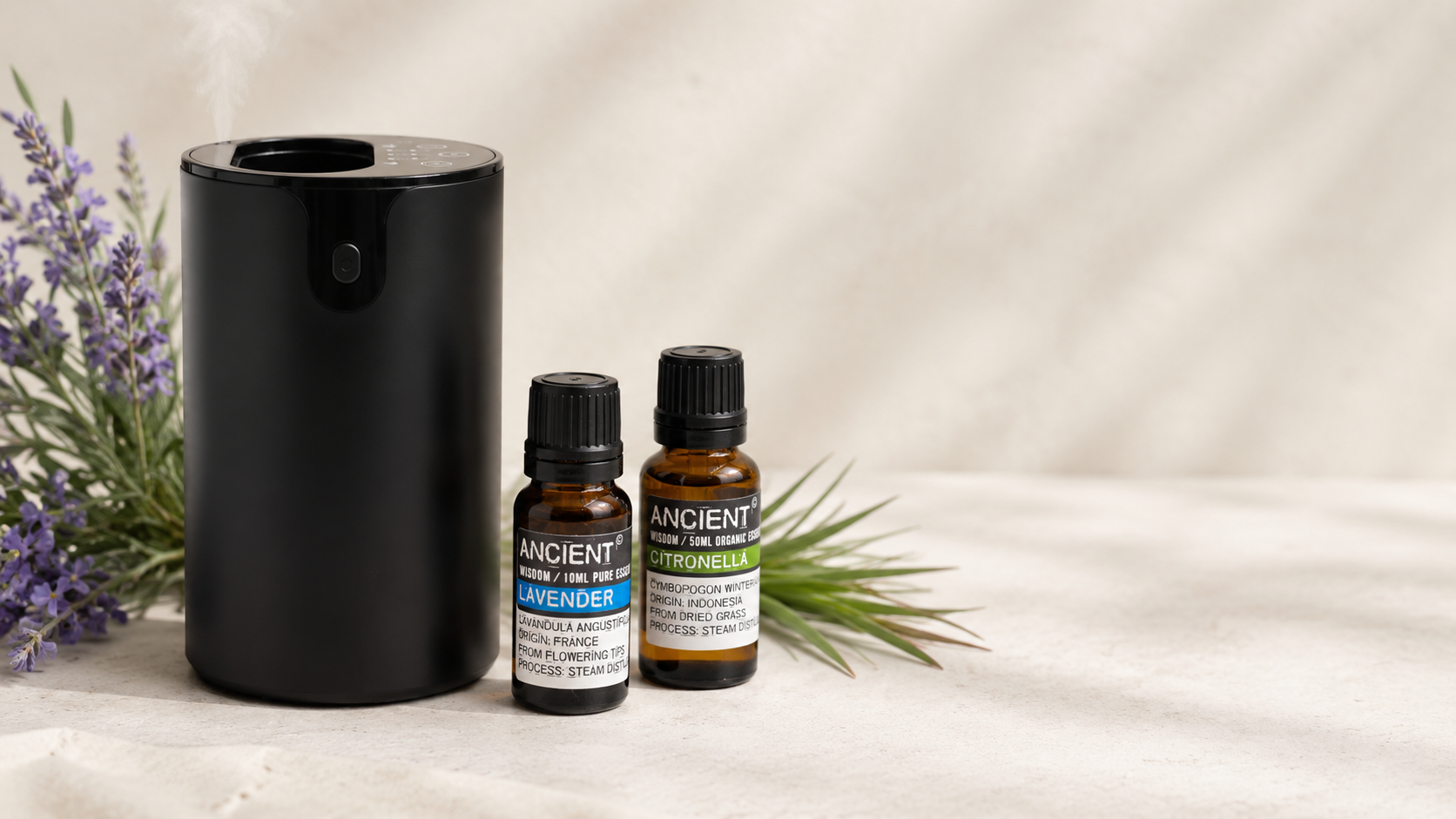 Difusor de aromaterapia junto a aceites esenciales, lavanda y cítricos sobre un fondo natural.