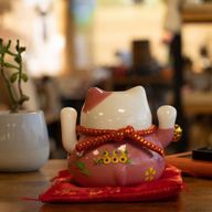 Gato de la suerte de cerámica con brazo móvil - Rosa sobre cojín (pilas no incluidas)